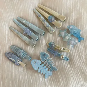 Detailed view of cute blue children hair clips set featuring shell, dolphin and starfish designs.