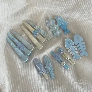 Cute blue hair clips set for kids, featuring dolphin and shell designs for sweet daily styling.