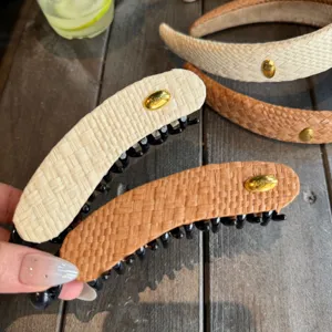 Ensemble pince banane et serre-tête en paille tressée avec logo en métal doré, accessoire élégant.