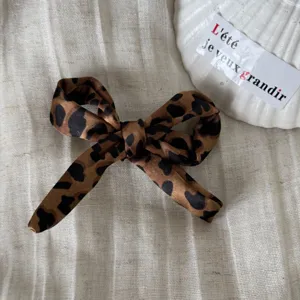 Chic pinza de pelo con lazo de leopardo vintage, elegante accesorio de tela para peinados.