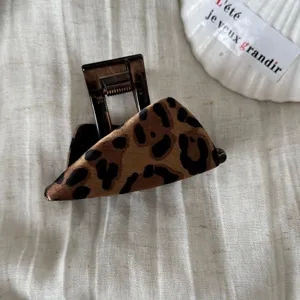 Vista detallada de la pinza de pelo con estampado de leopardo retro, accesorio elegante.