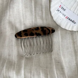Primer plano detalle de un elegante peine para el cabello con estampado de leopardo y metal.