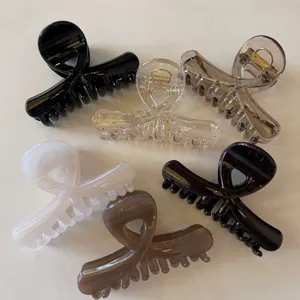 Dettagli delle pinze per capelli a croce lucide, in design traslucidi e solidi multicolore.