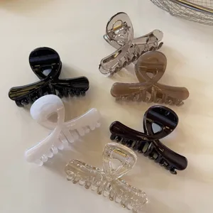 Primo piano dettaglio di mollette per capelli a croce lucide in vari colori per acconciature.