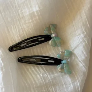 Vista detallada de lindas horquillas con lazo de acetato estilo coreano para peinados.