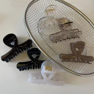 Dettaglio molletta per capelli incrociata lucida, elegante clip squalo in acrilico, accessorio.