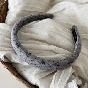 Cerchietto in tessuto grigio scuro con stampa elegante, accessorio per capelli vintage.
