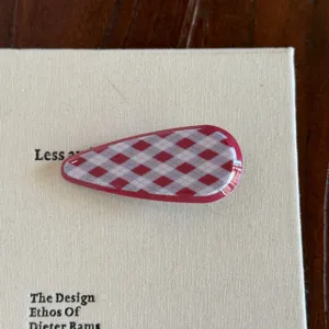 Vue détaillée de la pince à cheveux à carreaux rouge et blanc, épingle acétate.