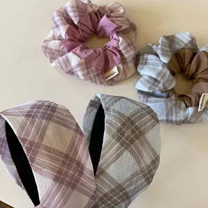 Λεπτομερής εικόνα από καρό scrunchies και στέκες, μαλακό ύφασμα και κομψός σχεδιασμός.