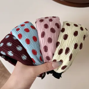 Detail shot of pleated polka dot wide headbands. Soft fabric texture for daily retro hair styling.