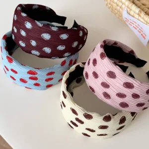 Detailed shot of retro wide-brim dot headbands in multi colors for chic daily hairstyles.