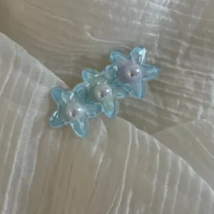 Blue star hair clip detail view, cute floral hair accessory for girls and daily styling.