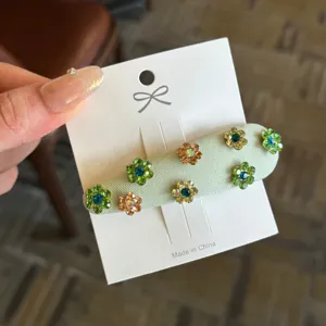 Primer plano detallado de una pinza para el cabello retro con strass floral verde claro.