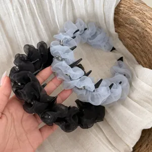 Vue détaillée de serre-tête plissés en organza bicolore avec dents et perles de cristal.