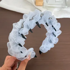 Vue détaillée du serre-tête élégant en organza bleu clair avec cristaux et dents.