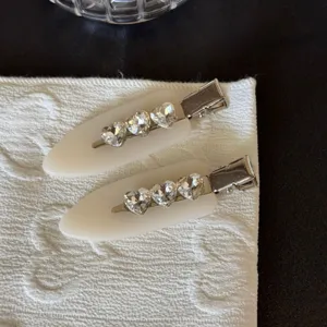 Primo piano dettagliato di fermagli per capelli con strass a cuore e base in resina.