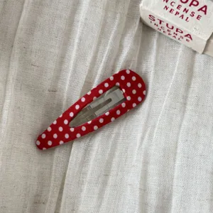 Red polka dot snap hair clip detail, cute fabric BB clip for daily hair styling and side bangs.