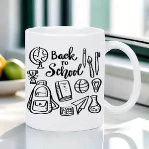 White ceramic coffee mug detail showing back to school black line art design on desk setup.