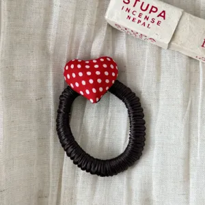 Cute dark hair scrunchie with red polka dot heart charm, perfect for daily styling and sweet looks.