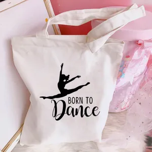 Close-up detail of white canvas tote bag featuring ballet dance girl graphic design.