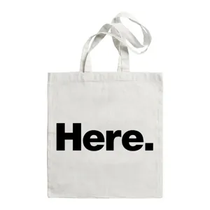 Gedetailleerd overzicht van witte canvas tote bag met zwarte letteropdruk, dagelijks gebruik.