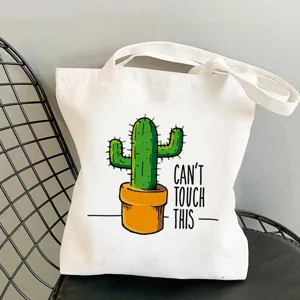 Dettaglio borsa shopper in tela con stampa di cactus verde in vaso e citazione divertente.