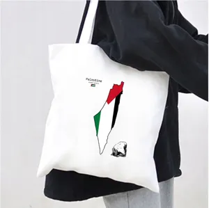 Close up view of a white canvas tote bag featuring Palestine map print and coordinates detail.