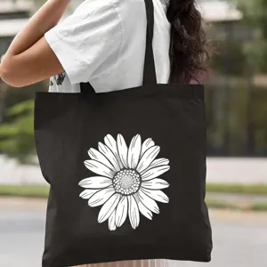 Gros plan sur le sac cabas en toile noire avec un imprimé marguerite blanche pour un usage quotidien.