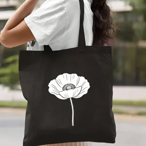 Détail de sac cabas en toile noire avec un design d'art au trait floral blanc pour le quotidien.