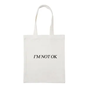 Detailed view of white canvas tote bag with black letter print, simple everyday style.