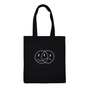 Detailed view of black canvas tote bag featuring unique overlapping facial graphic design.