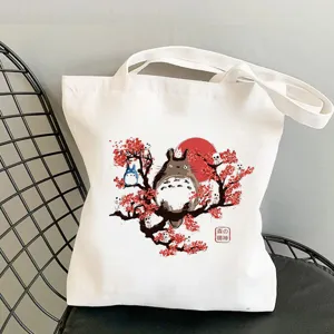 Detailed view of white canvas tote bag with cute anime character graphic print and handles.