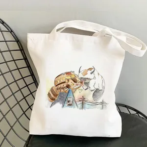 Detailed view of white canvas tote bag featuring cute anime print on a modern black wire chair.