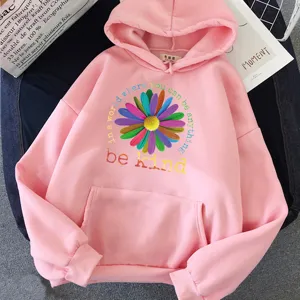 Détail de sweat à capuche rose avec imprimé de marguerite colorée et citation inspirante.