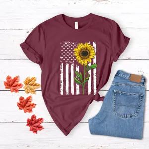 Vista de detalle plana de una camiseta burdeos con estampado de bandera de EE.UU. girasol.