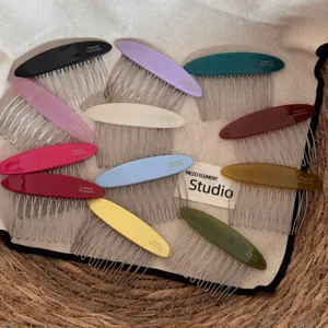 Detail view of multicolored oval acetate hair combs featuring metal teeth, delicate hair accessories.