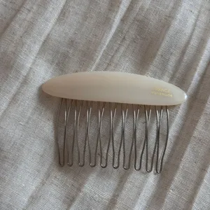 Detailed view of the elegant oval insert hair comb with acetate top bar and metal teeth.
