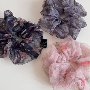 Gedetailleerd uitzicht van elegante bloemen chiffon haarelastiekjes, zacht stofontwerp.