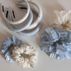 Detailed view of Korean sea salt blue daisy hair scrunchies and headbands set.