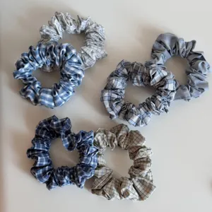 Blue plaid fabric hair scrunchies detail view, soft cloth texture and stylish checkered pattern.