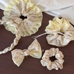 Gedetailleerd overzicht van gele bloemige scrunchies en schattige haarklemmen set.