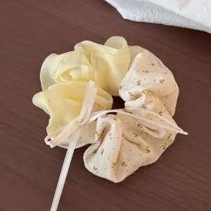 Gedetailleerde foto van gele bloemen haarelastiek met witte strik voor leuke staarten.