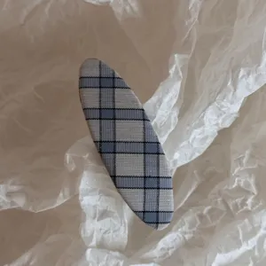 Close-up detail shot of a cute Korean style blue plaid hair clip, stylish hair accessory.