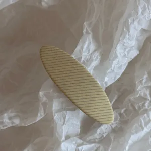 Primo piano dettagliato di una pinza per capelli in tessuto a quadri gialli e grigi.