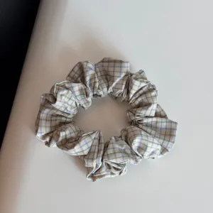 Plaid fabric hair scrunchie, soft elastic hair tie for women daily wear and styling details.