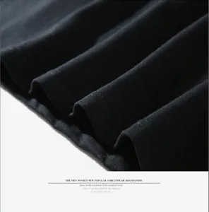 Close-up detail shot of black fabric with fine texture and neat pleats, highlighting material.