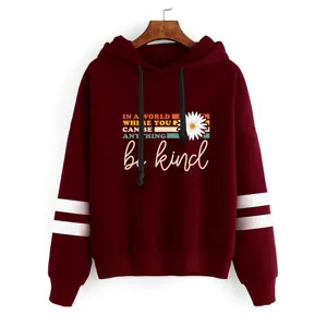 Détail de sweat à capuche bordeaux avec des rayures de manches et un imprimé inspirant.
