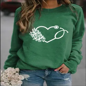 Nahaufnahme Detail des grünen Rundhals-Sweatshirts mit weißem floralen Herz-Stethoskop-Druck.