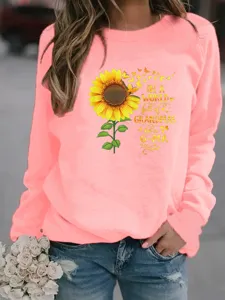 Vue détaillée du sweat-shirt graphique rose avec impression de tournesol et de citation.