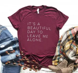 Détail de t-shirt graphique bordeaux avec impression de slogan et style streetwear décontracté.